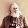 Portrait white man in suit military medal long wavy hair thick beard smoking large pipe