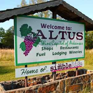 "Welcome to Altus" sign with brick base and roof