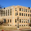 three story concrete building with lamp posts in front