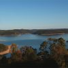 Lake with tree covered shores and hills in the distance