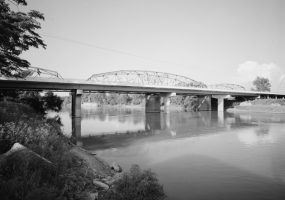 Highway bridge and river with river bank in foreground