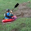 White man in kayak in muddy ditch