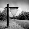 wooden post with triangular sign next to rural highway "Camp Ouachita Girl Scout Camp, Ouchita National Forest"