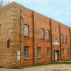 Corner view of multistory rectangular brick building with flat roof