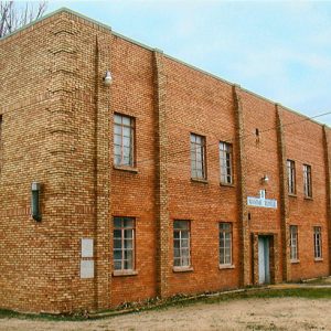 Corner view of multistory rectangular brick building with flat roof