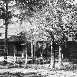 Log cabin with trees in front of it