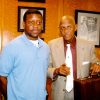 Young African-American man and older African-American man with suitcase in suit and tie