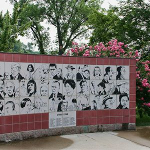 hand-drawn faces on black and white tiles on memorial wall