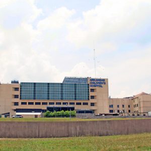 Multistory concrete complex with large windows viewed from across recessed highway