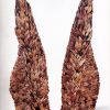 Large freestanding sculpture resembling wings made of found women's shoe soles on white backdrop