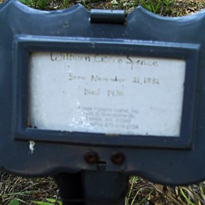 black metal grave marker with inscription on white card