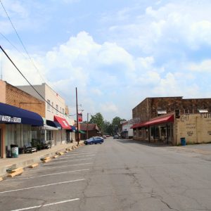 "Clinton water & sewer" building with brick and stone store fronts on street