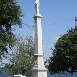 Statue of soldier on obelisk monument with base on street