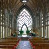 Interior of chapel sanctuary with pews and arched roof supports