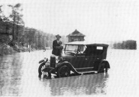 man sitting on car in flooded road
