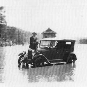 man sitting on car in flooded road