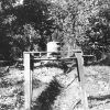 Oil can on sawhorse above ditch dug in the ground