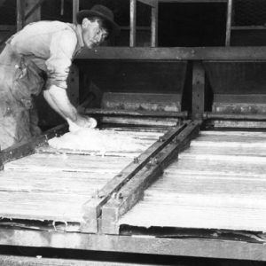 White male miner in overalls, hat, operating equipment