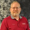 White man with glasses and beard in striped red collared shirt