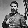 white man with beard poses with one hand inside military jacket