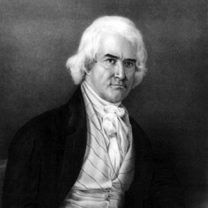 Portrait white man seated stern expression bushy white hair dark eyebrows suit cravat striped vest