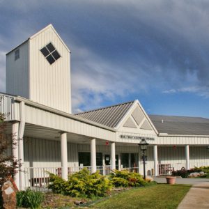 Single-story building with covered porch and tower with diamond shaped window