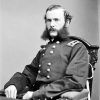 white man with mutton chops in military regalia sitting in chair