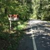 "Ozark Highlands Trail parking" sign with street and trees on both sides