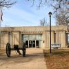 stone and glass building with cannon in front