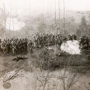 Group of soldiers with guns on battlefield with a few men fallen to the ground