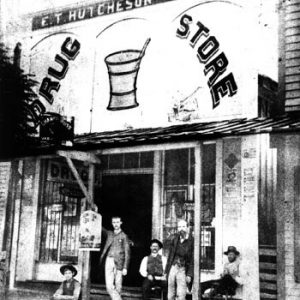 men lounging in front of drug store