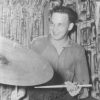 Signed photo of young white man playing drums in front of curtains