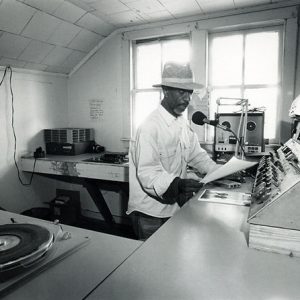 African-American man with hat working in radio station