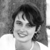 Young white woman with loop earrings and necklace in white