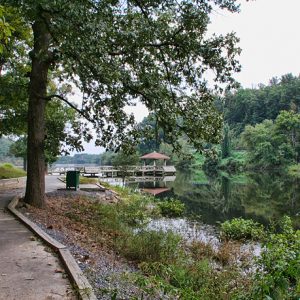 paved walkway leading to gazebo over a lake