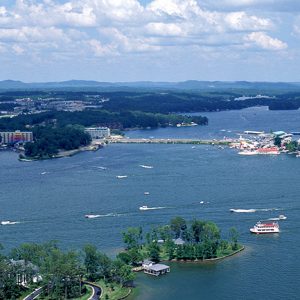 Bridge spanning large lake as seen from above with town in the distance