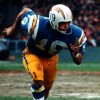 white man running in football uniform number nineteen