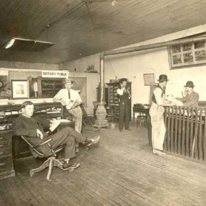 Five white men in suits in a printing office