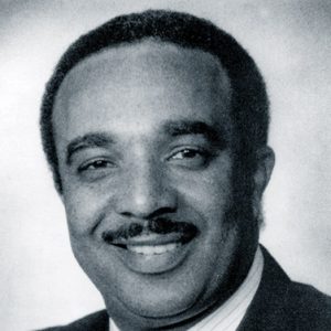 African-American man with mustache in suit and tie