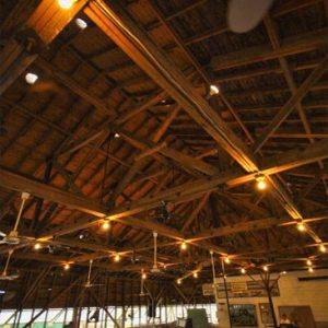 Interior of building with wood trusses and rows of pews