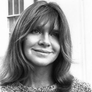 Young white woman with long hair smiling in sweater