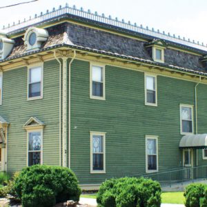 two story boxy green Victorian building