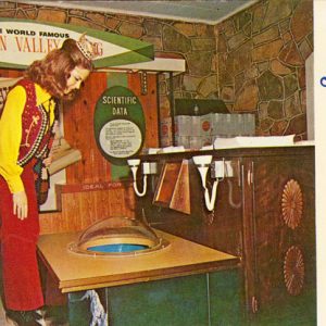 white woman looks into glass dome on floor of Mountain Valley Spring Water showroom