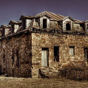 Abandoned two-story brick and stone building in field