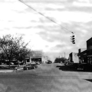 street intersection with hanging streetlight and one and two story buildings around