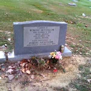 "Robert McCollum" grave marker in cemetery with beer can and flowers on his grave