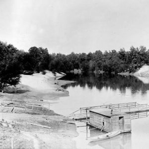 Canoe at floating dock house on river next to floating dock with railings