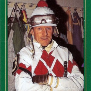 card with green and gold border featuring whtie man in jockey uniform "Perry Ouzts Journeyman"