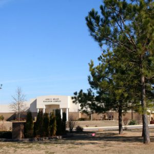 building behind trees "John E. Miller Education Complex"