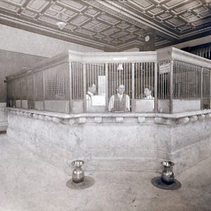 Bank interior with three tellers behind barred counters, two spittoons